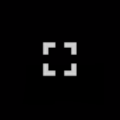 Zdjęcie przedstawia ikonę włączenia trybu pełnoekranowego filmu. Składa się ona z czterech kątów prostych, które tworzą kształt kwadratu. Ikona jest biała, a tło zdjęcia czarne.