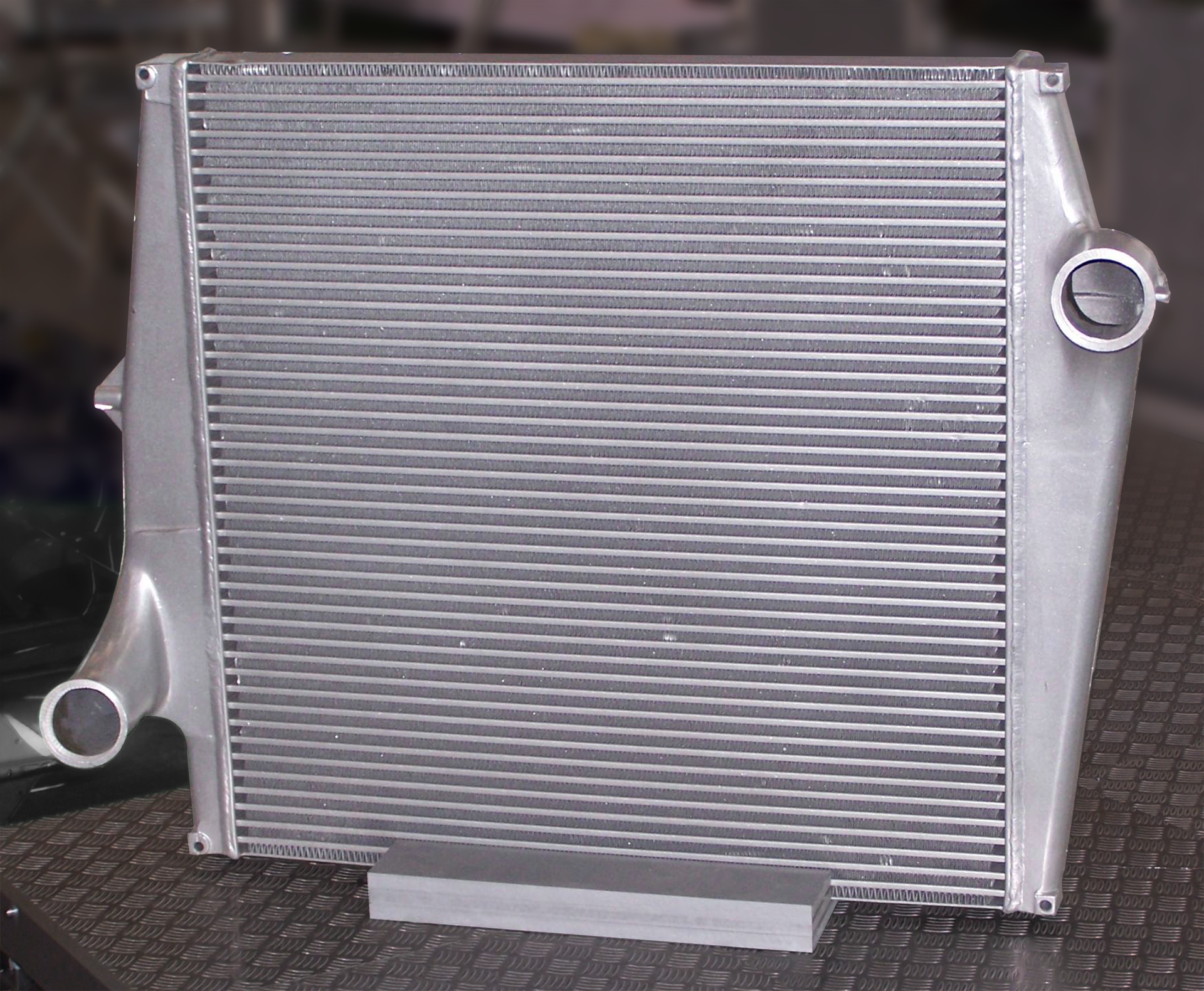 Seria zdjęć obrazująca wykorzystanie przewodników i izolatorów ciepła. Przewodnik cieplny – aluminium, w postaci szarej, prostokątnej chłodnicy samochodowej.