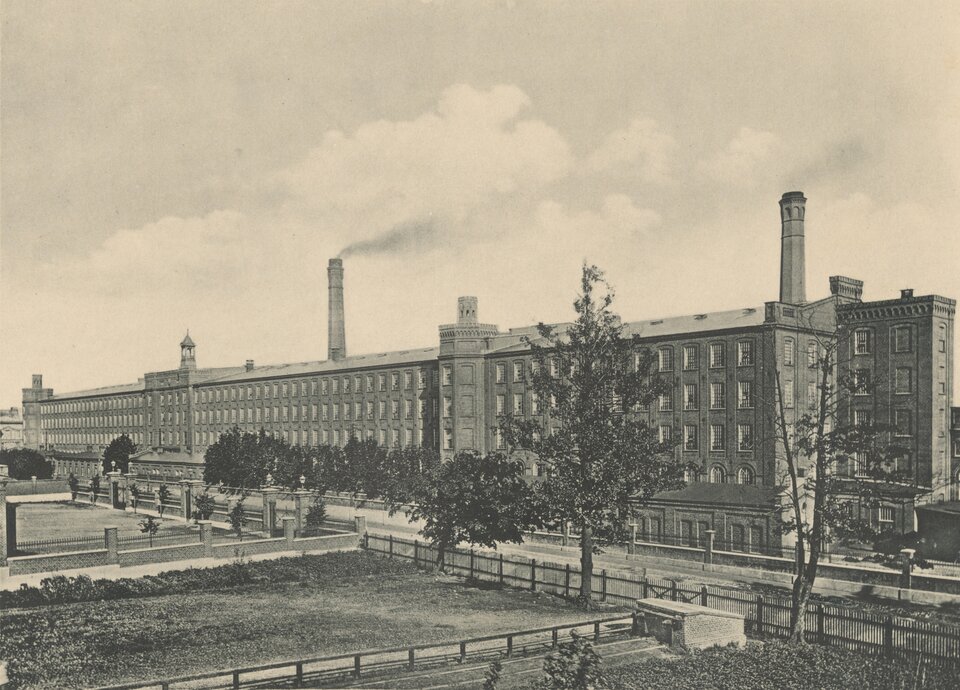 Szkic przedstawia ogromną kilkupiętrową fabrykę. Z tyłu zza jej głównej części wystają kominy, z których leci dym. Przed budynkiem znajduje się ulica oraz park z drzewami. 