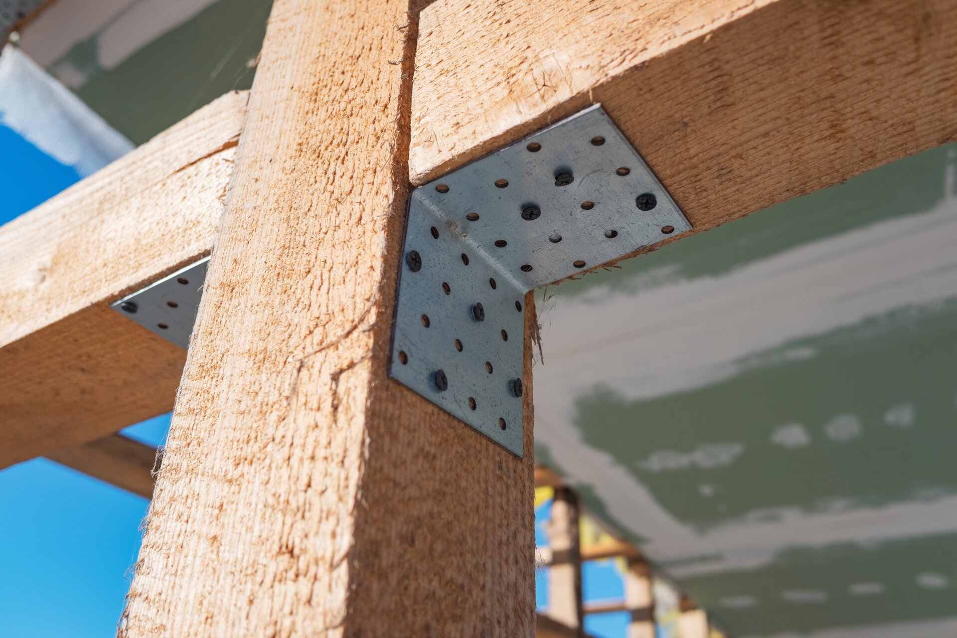 Zdjęcie przedstawia połączenie belek za pomocą kształtownika. Kształtowniki przylegają do belek i łączeń.