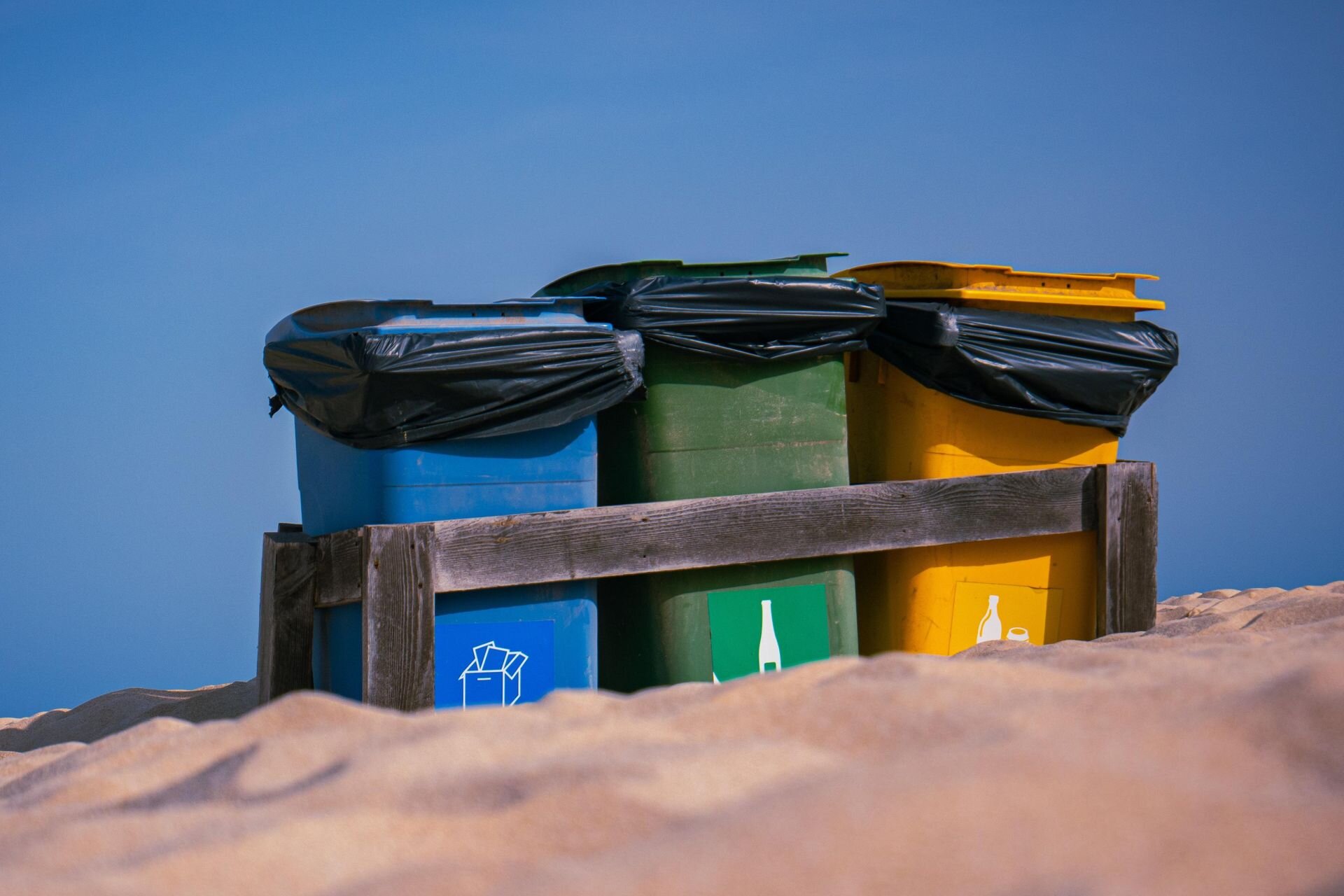 Ilustracja przedstawia trzy pojemniki na odpady. Niebieski zielony i żółty.