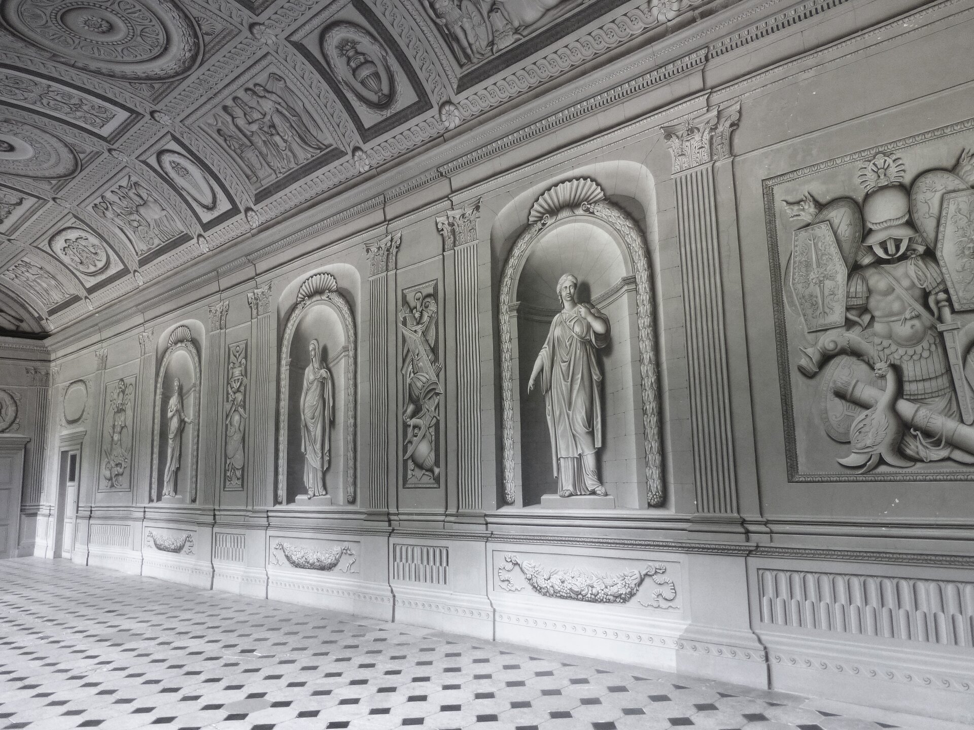 Ilustracja przedstawia malarstwo ścienne w Château de Tanlay[czytaj: szato de tanli]. Ukazuje wnętrze francuskiego zamku. Widoczna jest sala, w której ozdobienie sufitu naśladuje płaskorzeźbę. W szarym odcieniu przedstawione zostały elementy dekoracyjne. Ściana i sufit mają szary kolor. Sufit jest zdobiony namalowanymi ornamentami oraz przedstawieniami figuralnymi. Na ścianach są namalowane wnęki z postaciami, a pomiędzy nimi, w czworokątnych polach, znajdują się obrazy przedstawiające rycerskie zbroje.