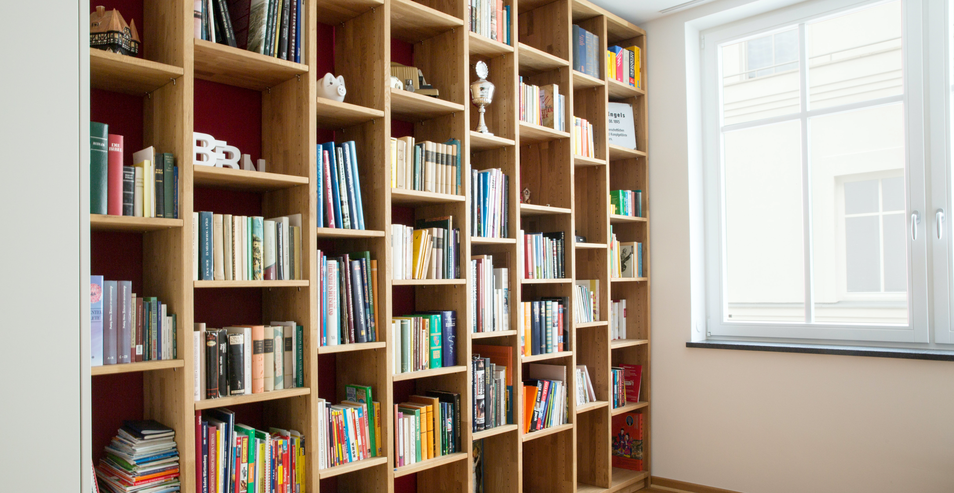 Zdjęcie przedstawia regał z półkami pełnymi książek.