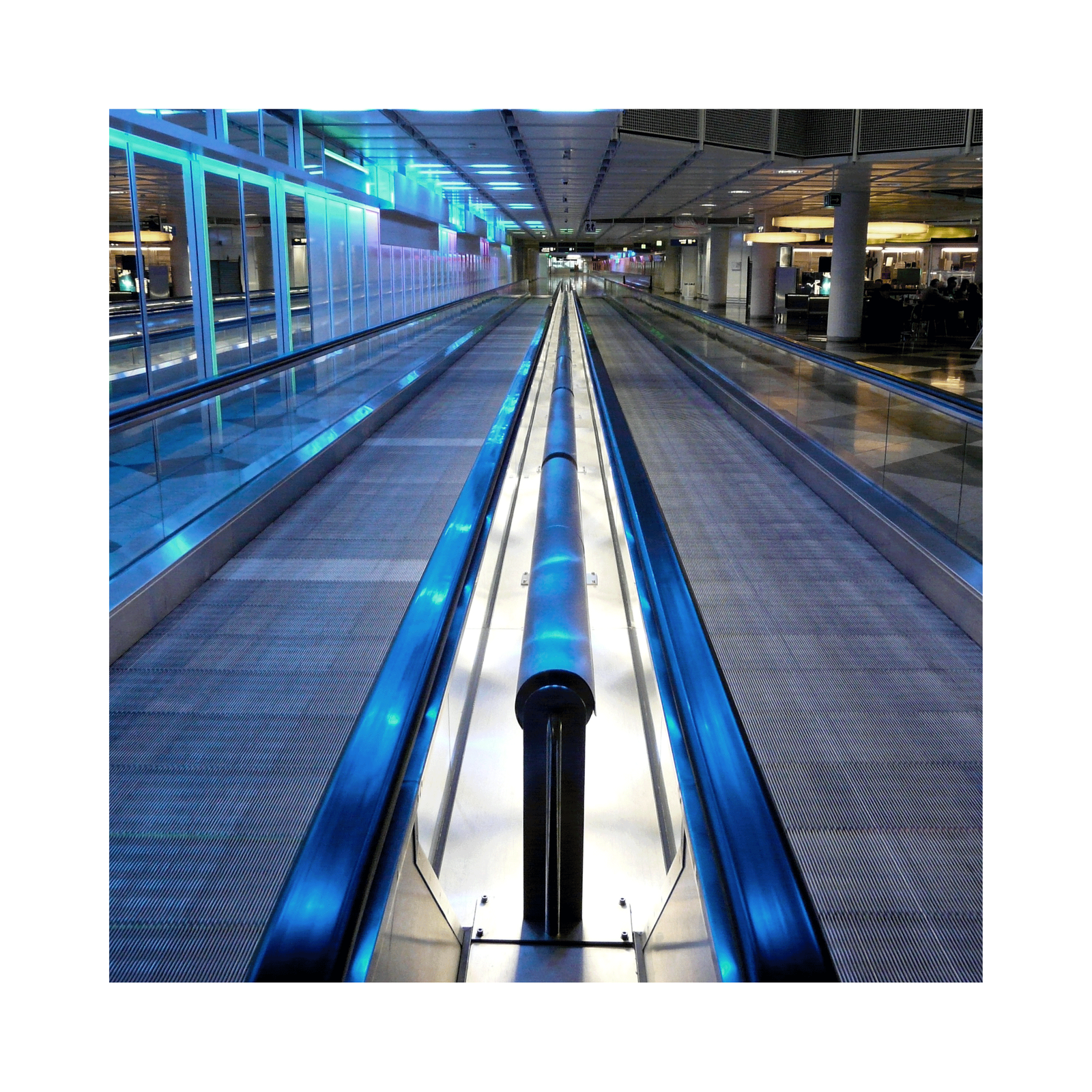 Zdjęcie przedstawia dwa chodniki ruchome. Między nimi jest jedna stała poręcz, a po obu stronach chodników są ruchome poręcze.