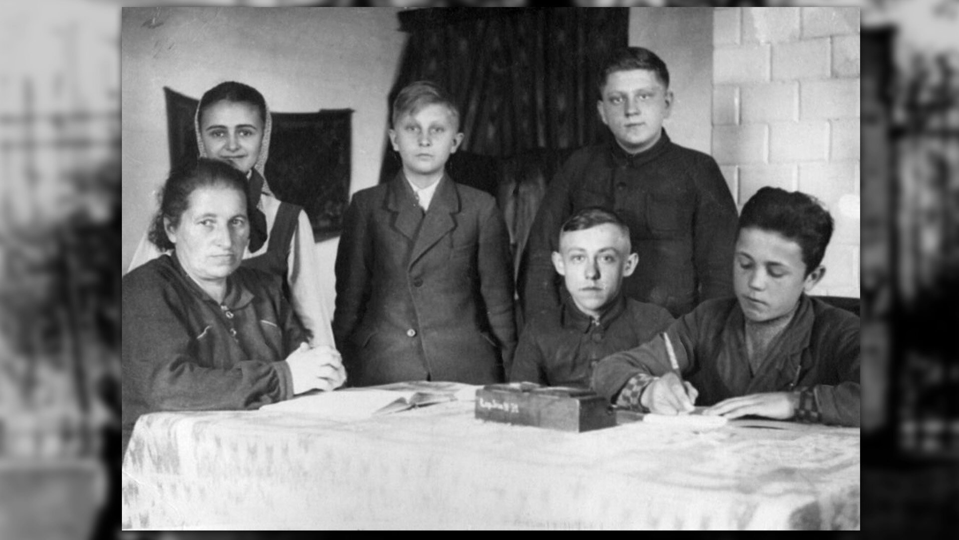 Fotografia czarno-biała przedstawiająca lekcję polskiego podczas edukacji podziemnej. Zajęcia prowadzone przez Jadwigę Sokirkówną.