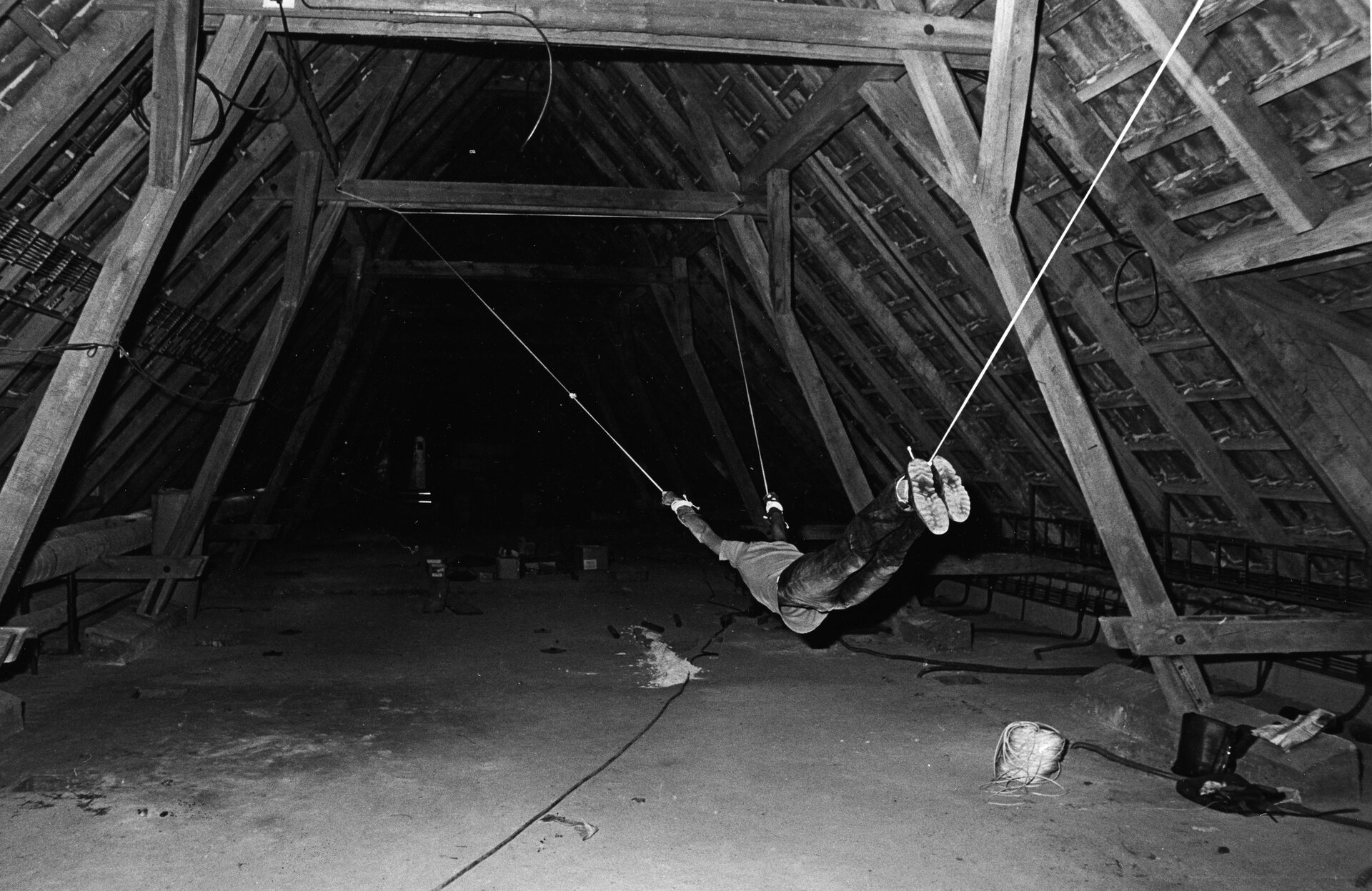 Performance przedstawia strych jednego z budynków w Pradze. Mężczyzna wisi zawieszony pod dachem i przypięty jest do elementów konstrukcyjnych budynku.