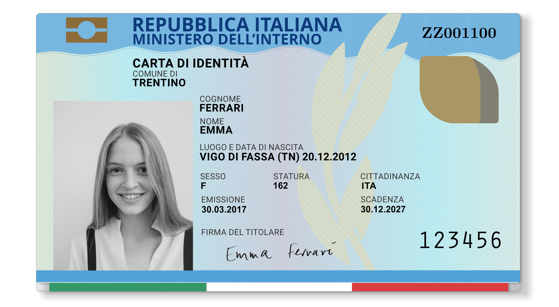 Grafika przedstawia włoski dowód osobisty. Po lewej stronie znajduje się zdjęcie uśmiechniętej młodej dziewczyny. W prawym górnym rogu znajduje się nr dowodu:  ZZ001100. Poniżej znajdują się dane osoby do której należy dowód. Dane w dowodzie: Comune di: Trentino, Cognome: Ferrari, Nome: Emma, Luogo e data di nascita: Vigo Di Fassa (TN) 20.12.2012, Sesso: F, Statura: 162, Cittadinanza: ITA, Emissione: 30.03.2017, Scadenza: 30.12.2027.
