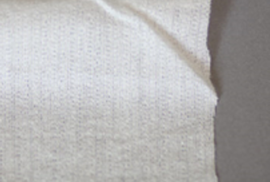 Zdjęcie przedstawia kawałek materiału w beżowym kolorze.