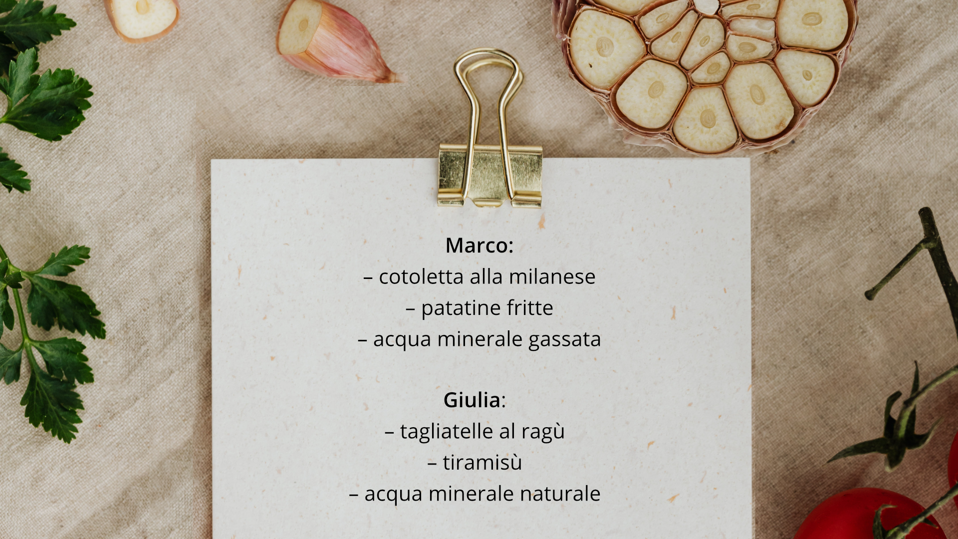 Zdjęcie przedstawia kartkę z notatkami przypiętą spinaczem. Kartka leży na stole. Obok widoczna jest przekrojona główka czosnku oraz natka pietruszki. Na kartce znajduje się tekst: Marco: cotoletta alla milanese, patatine fritte, acqua minerale gassata. Giulia: tagliatelle al ragù, tiramisù, acqua minerale naturale.