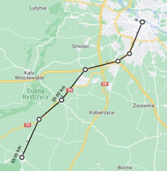 Na ilustracji fragment mapy. Na mapie łamaną zaznaczono trasę. Trasa biegnie odcinkami, od punktu do punktu, na południowy wschód. Na trasie zaznaczono odległość dwudziestu kilometrów od początku trasy oraz trzydziestu trzech kilometrów od początku trasy.