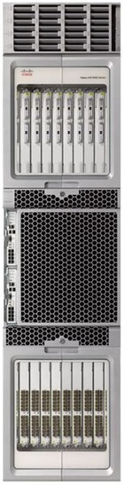 Zdjęcie przedstawia Ruter CISCO ASR z serii 9900. Jest on w kształcie prostokątna. Na przedstawionej tylnej części urządzenia znajduje się duża kratka wentylacyjna. Pod kratką i nad nią znajduje się wiele specjalistycznych złącz.