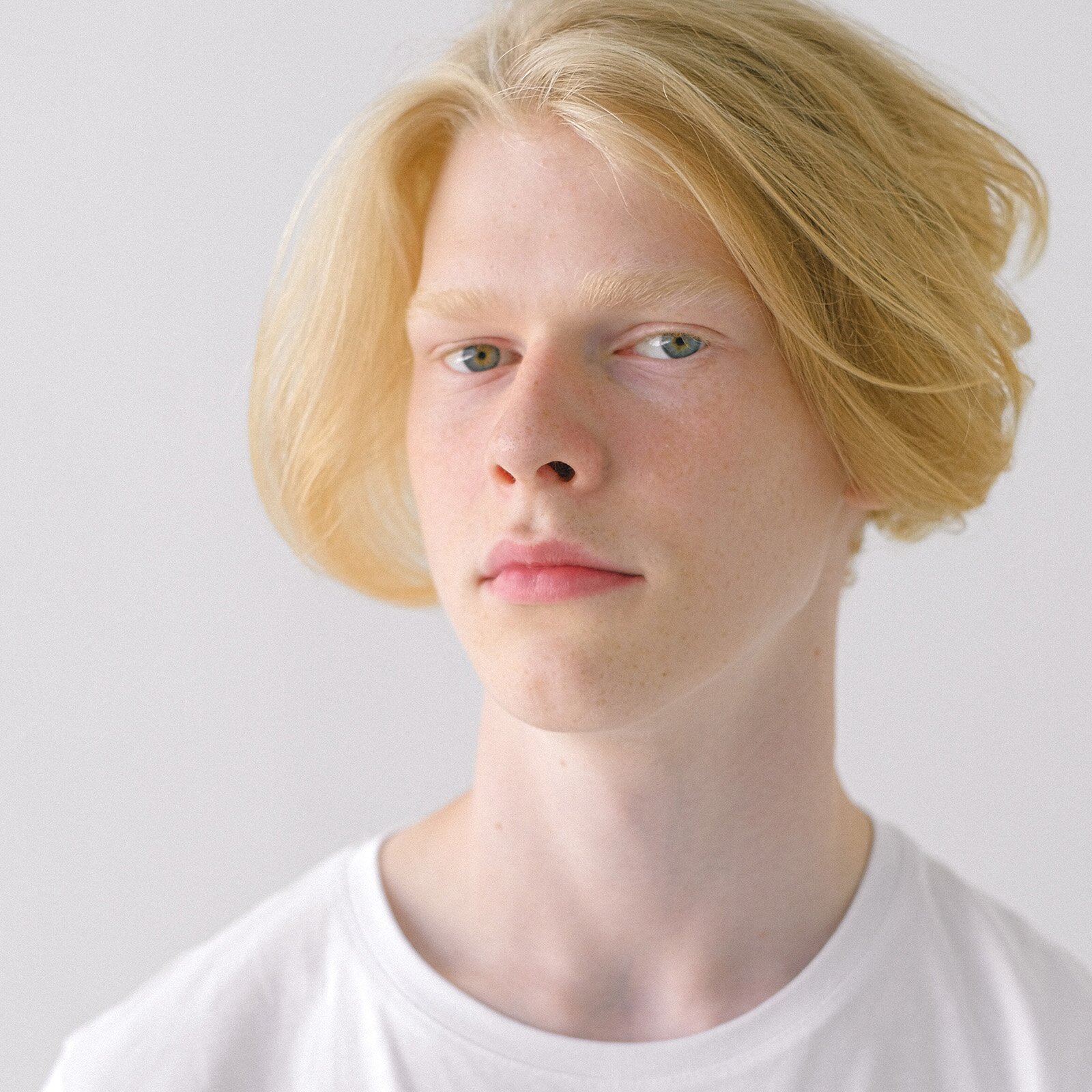 Zdjęcie przedstawia nastolatka o jasnej karnacji z blond włosami i niebieskimi oczami. Jego brwi i rzęsy też są jasne prawie niewidoczne. 