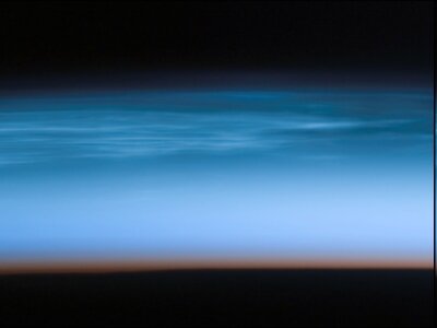 Zdjęcie przedstawia chmury w mezosferze. Od góry i od dołu znajdują się czarne wąskie pasy przestrzeni. Pomiędzy nimi są polarne chmury mezosferyczne.