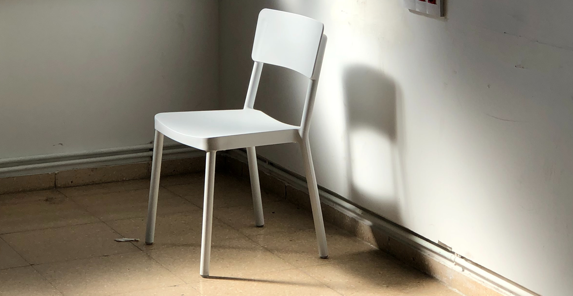 Zdjęcie przedstawia krzesło stojące przy ścianie.