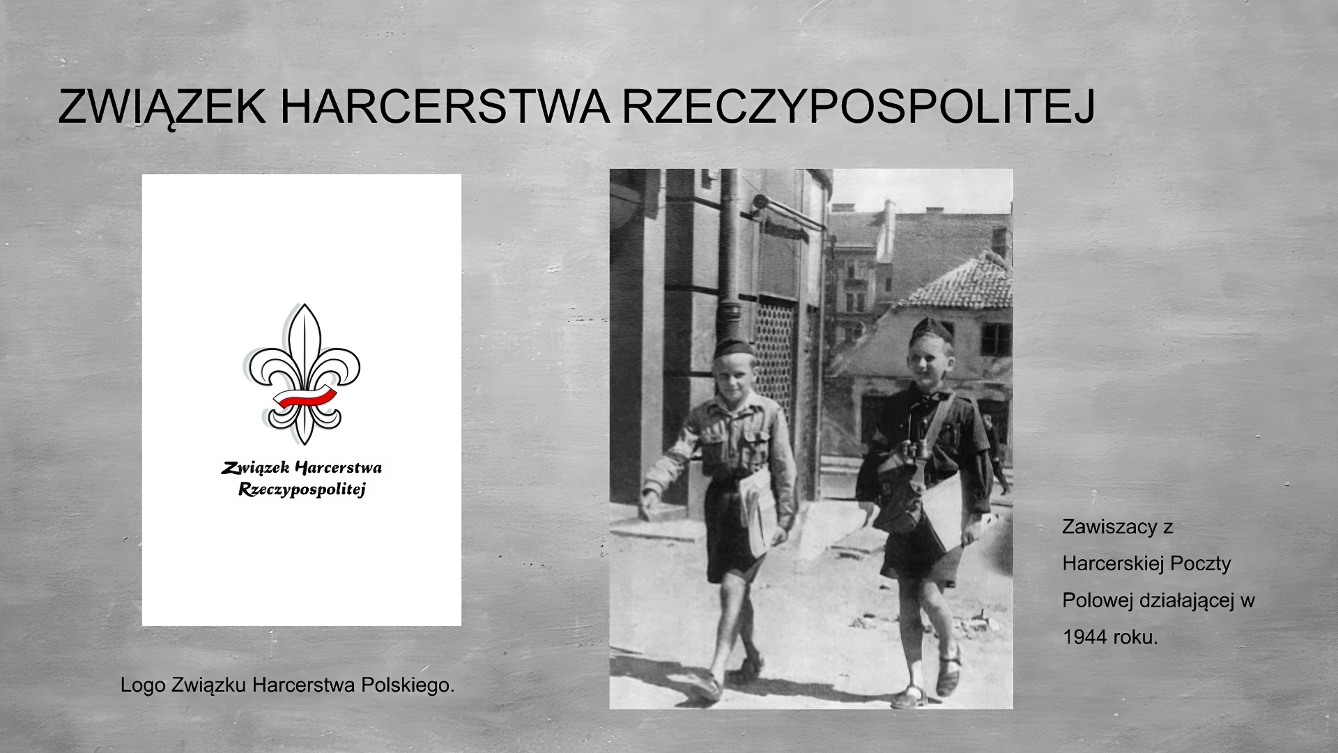 Slajd przedstawia szare tło, na górze tytuł: ZWIĄZEK HARCERSTWA RZECZYPOSPOLITEJ. Po lewej stronie grafika przedstawiająca logo zhr: białe tło, a w nim czarna lilijka harcerska z biało czerwoną szarfą. Poniżej napis: Związek Harcerstwa Rzeczypospolitej. Pod spodem podpis: Po prawej stronie czarno białe zdjęcie przedstawiające maszerujących dwóch młodych harcerzy ubranych w mundury z chustami, spodenkami do kolan, na głowie mają czapki. W lewych rękach trzymają teczki, harcerz po prawej stronie na prawym ramieniu ma przewieszoną torbę. Na lewym ramieniu harcerze mają biało czerwone opaski.