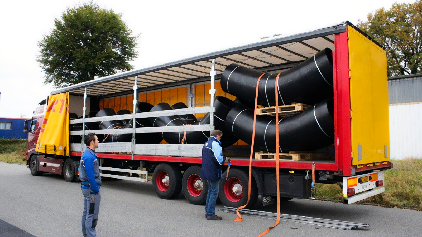 Zdjęcie przedstawia transport kolan. Widać samochód ciężarowy, na którego pace znajdują się przywiązane do palet kolana.