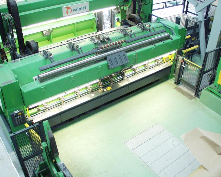 Na zdjęciu przedstawiono sekcję automatycznych noży tnących wstęgę papieru. Urządzenie znajdujące się w tej sekcji wyposażone jest w rolki umożliwiające przesuwanie papieru oraz system noży nadający mu odpowiedni kształt.