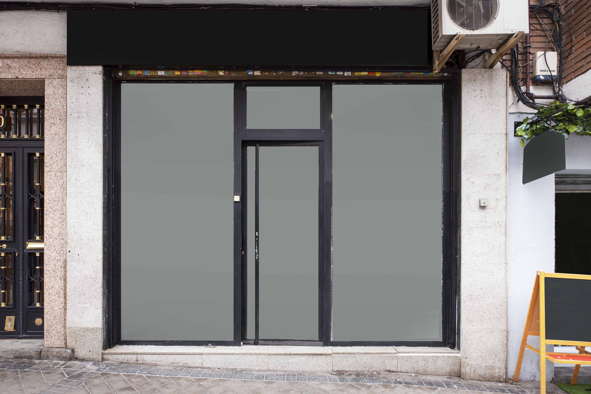 Zdjęcie przedstawia drzwi zewnętrzne z PVC o szarym kolorze i ciemnogranatowych ramach wyznaczających granicę czterech skrzydeł.