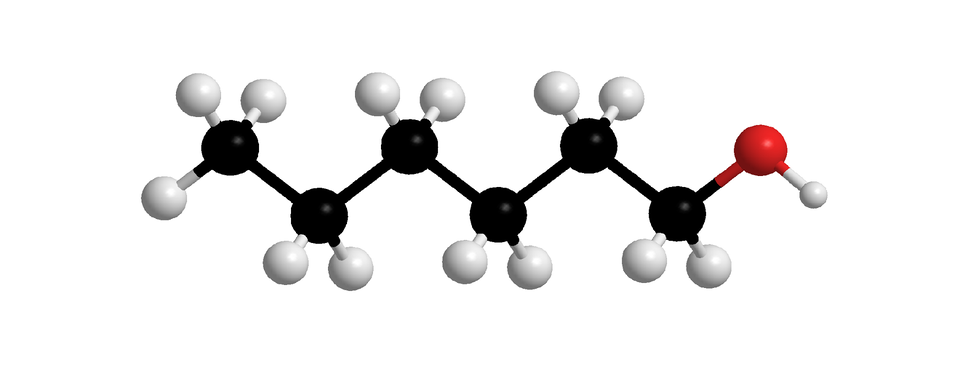 Ilustracja przedstawia model kulkowy cząsteczki heksan–jeden–olu. Czarna kulka to węgiel, biała to wodór, czerwona to tlen. Cząsteczka składa się z jednego atomu węgla, połączonego z trzema atomami wodoru, i kolejno z pięcioma atomami węgla, łączącymi się z dwoma atomami wodoru, połączonymi szeregowo. Ostatni z nich poza dwoma atomami wodoru ma przyłączony jeden atom tlenu. Atom tlenu z kolei wiąże się z atomem wodoru tworzą grupę hydroksylową. Atomy węgla tworzą zygzak.