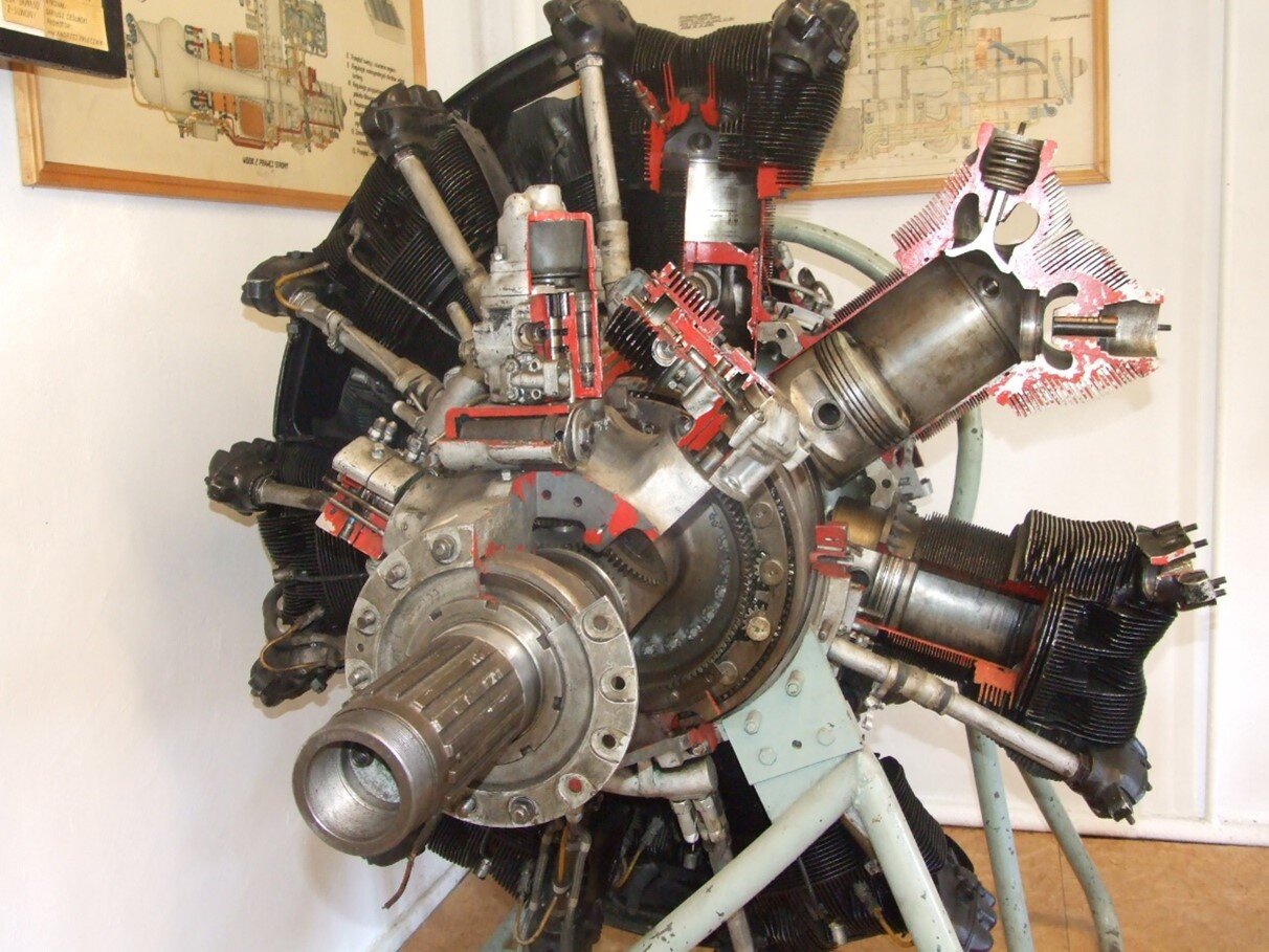 Zdjęcie przedstawia silnik gwiazdowy. Jest to konstrukcja, w której cylindry umieszczone są promieniowo na obwodzie koła, z centralnym wałem korbowym. 