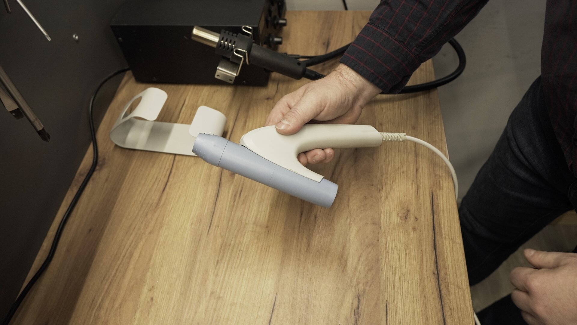 Na zdjęciu technik trzyma w dłoni zmontowany przetwornik spirometru.