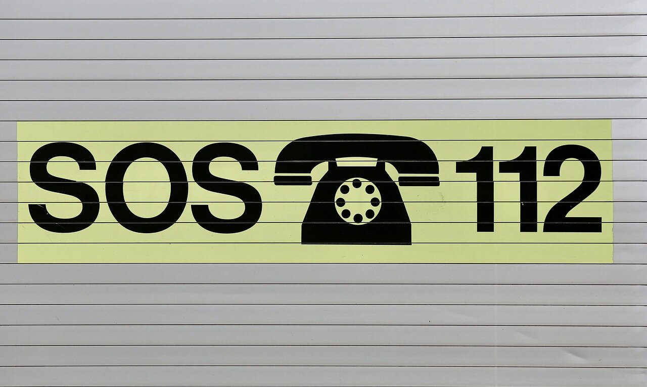 Plansza z napisem SOS, symbolem telefonu z numerem 112.