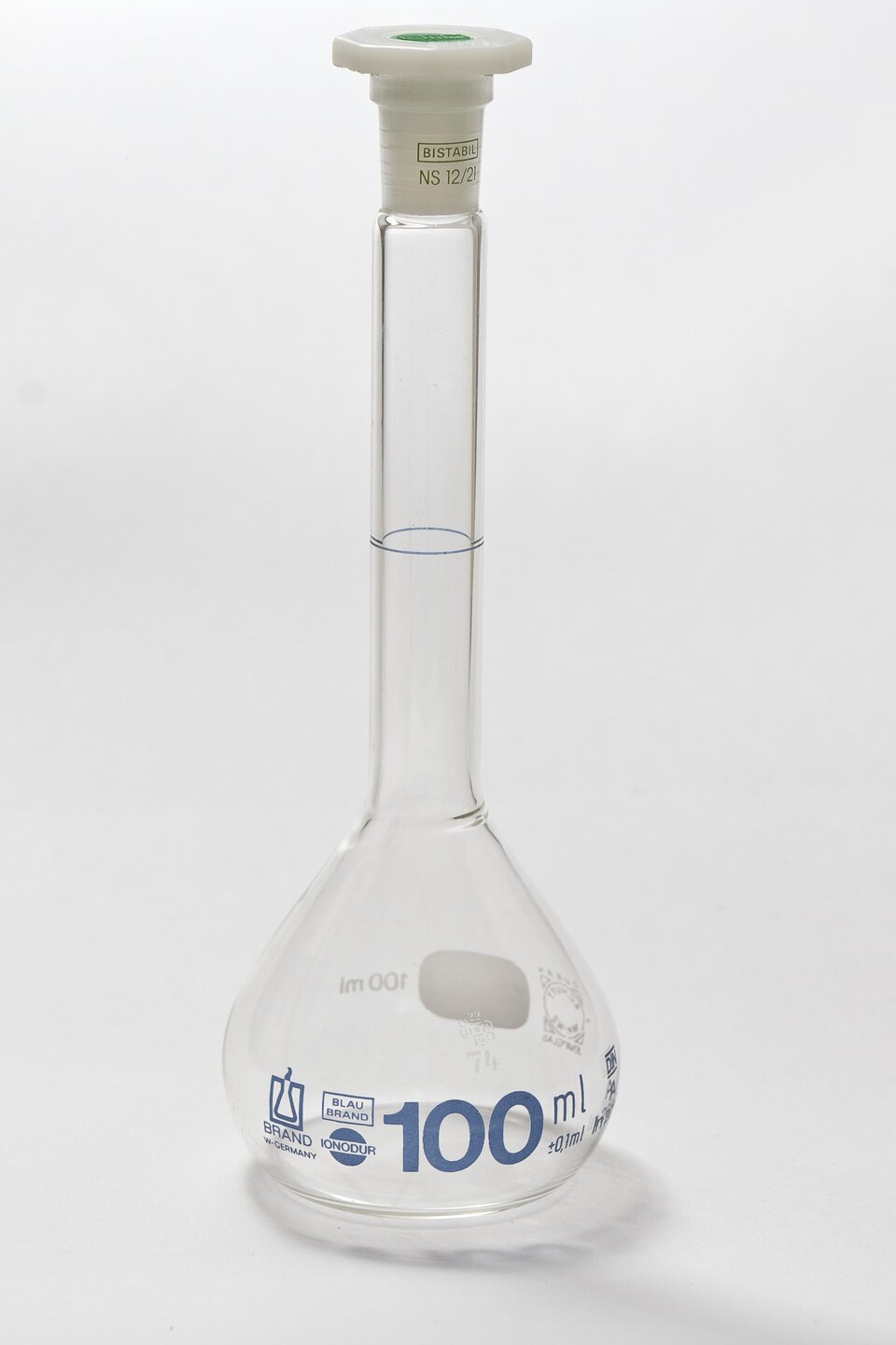 Kolba miarowa o objętości 500 cm<sup>3</sup> Zdjęcie przedstawia szklaną kolbę miarową wykorzystywaną w chemicznej analizie ilościowej do sporządzania roztworów mianowanych. Kolba posiada jedną kreskę zaznaczoną na długiej, wąskiej szyjce. Kreska ta oznacza miejsce, do którego należy napełnić kolbę aby uzyskać objętość na jaką jest wyskalowana kolba. Kolba zatkana jest teflonowym korkiem.