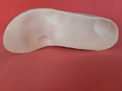 Zdjęcie przedstawia wyścielenie wkładki ortopedycznej, z pogłębionymi ubytkami na miejsca bolesne.