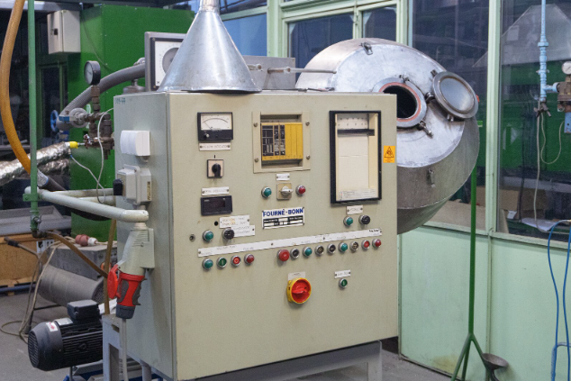 Na ilustracji jest urządzenie w postaci skrzynki. W przedniej części znajdują się przyciski, wskaźniki. W górnej części skrzynki znajduje się element przypominający odwrócony lejek. Z boku skrzynki jest metalowy bęben.