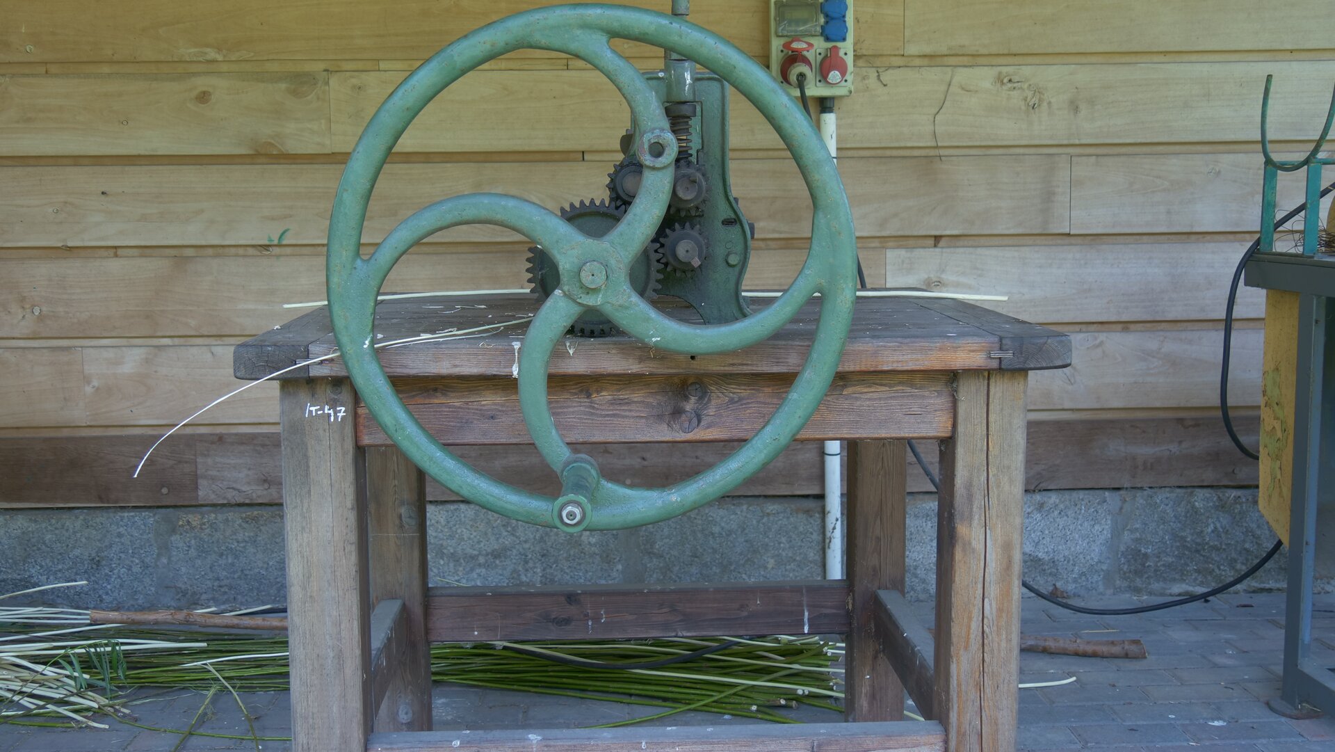 Zdjęcie przedstawia taśmiarkę ręczną z widocznym na pierwszym planie kołem zamachowym.
