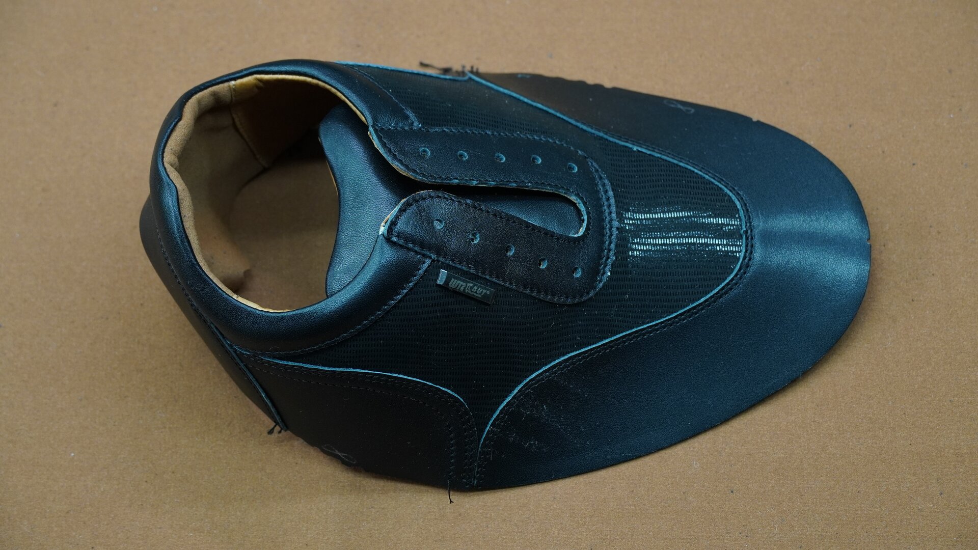 Zdjęcie przedstawia kawałek materiału w kolorze turkusowym, uformowany w kształt cholewki, czyli owalny. Przód jest zaokrąglony.