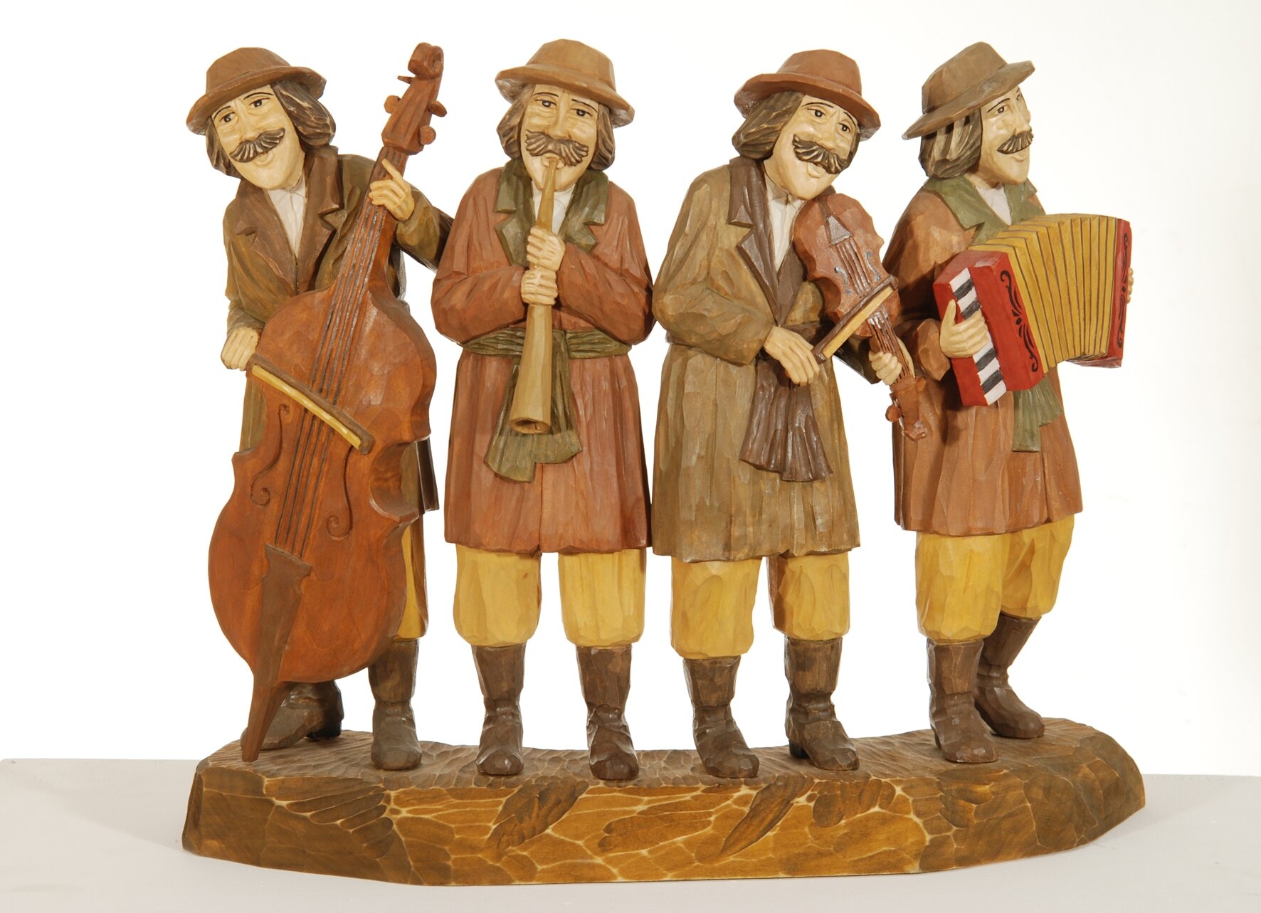 Drewniana rzeźba przedstawiająca czterech muzykantów. Rzeźba jest pomalowana na stonowane kolory. Wszyscy czterej muzykanci mają duże wąsy i kapelusze, brązowe buty, szerokie spodnie oraz płaszcze wiązane w pasie. Mężczyzna z lewej strony gra na kontrabasie, następny na rogu, kolejny na skrzypcach, a ostatni na akordeonie.