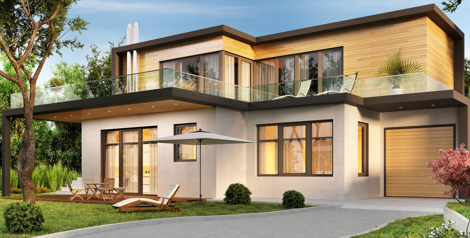 Zdjęcie przedstawia dom z dachem płaskim. Dom jest w nowoczesnym stylu. Niektóre jego ściany są pokryte drewnem. Przed budynkiem znajdują się leżaki i parasol.