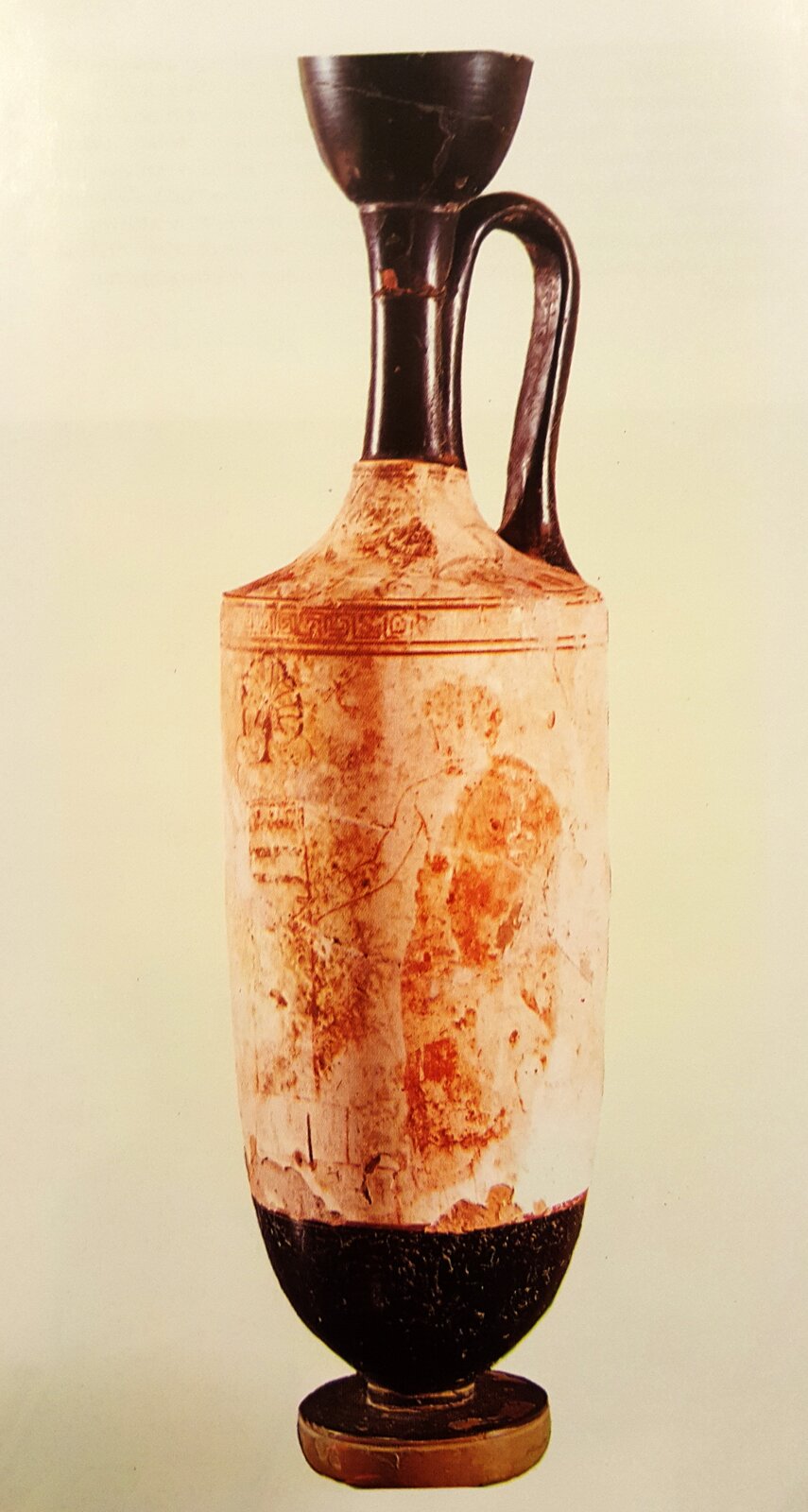 Ilustracja przedstawia starożytną wazę z jednym uchem. Ukazuje ledwie widoczną sylwetkę postaci. Nad nią znajduje się pas obiegający wazę z motywem dekoracyjnym. Górna i dolna część wazy są czarne.