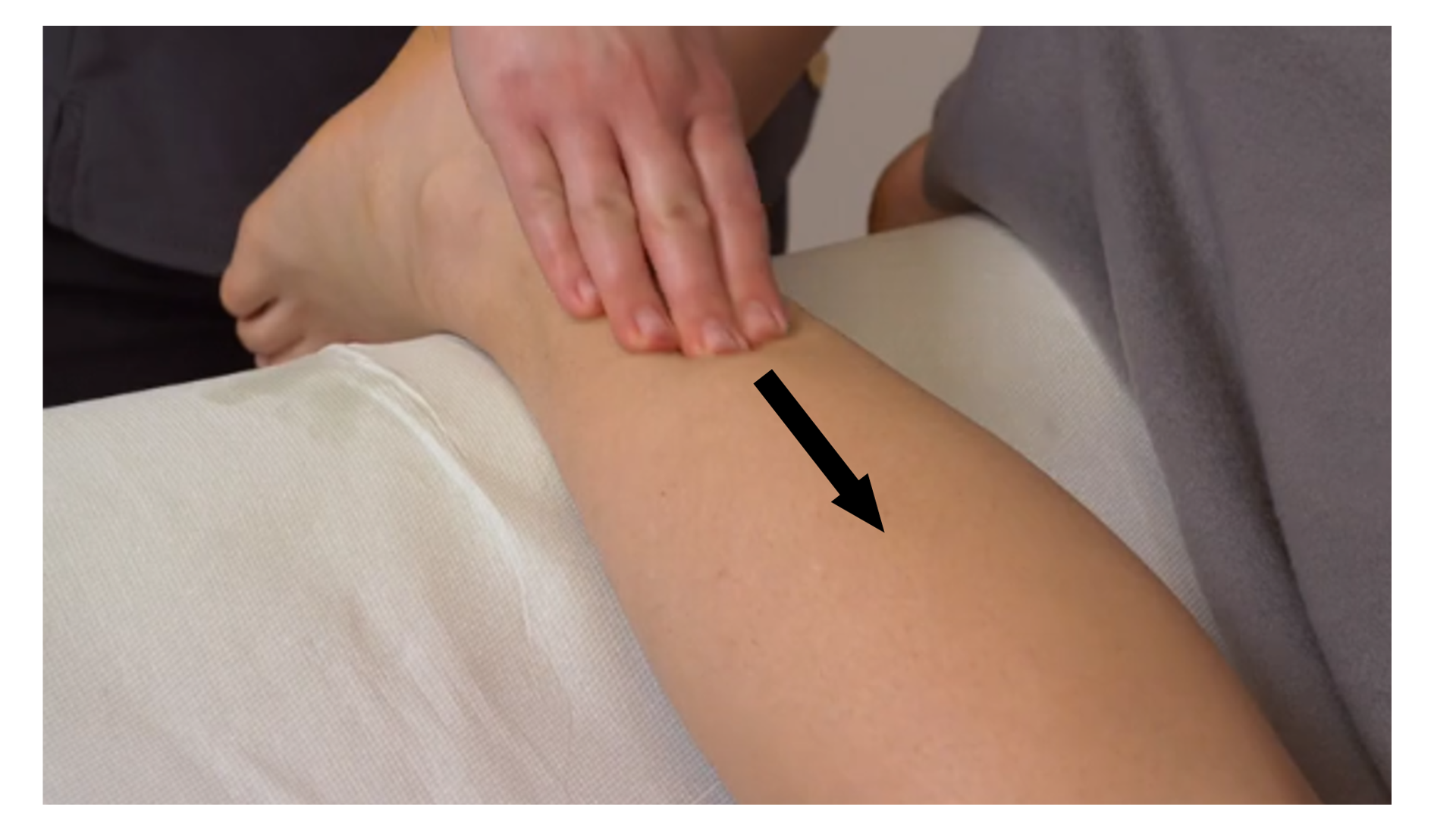 Zdjęcie pod tytułem głaskanie powierzchniowe i głębokie ścięgna Achillesa. Na zdjęciu jedna ręka masażystki podtrzymuje stopę leżącej na brzuchu pacjentki. Druga ręka rozciera przy użyciu opuszków palców rejon ponad piętą pacjentki.