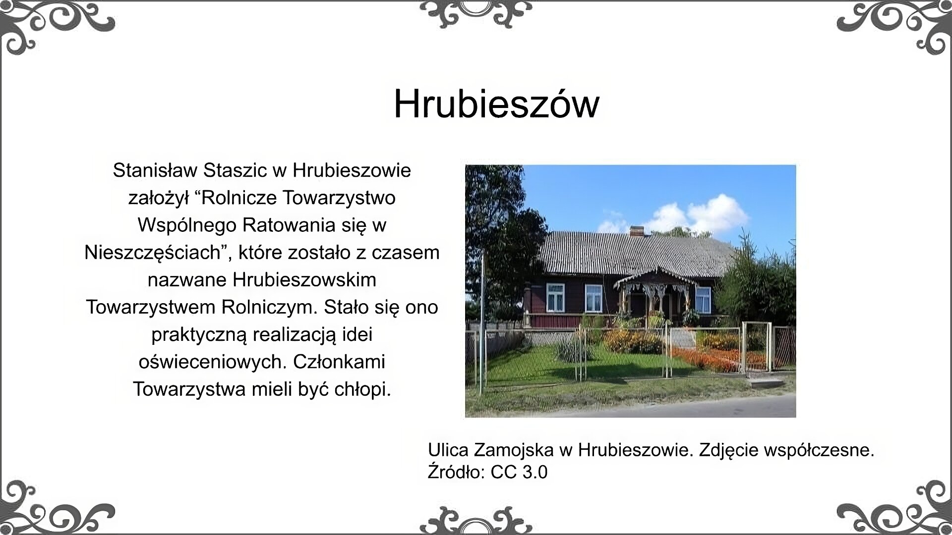 Slajd zatytułowano: Hrubieszów. Ilustracja przedstawia fragment współczesnej ulicy. Przy ulicy znajduje się parterowy dom ze skośnym zadaszeniem. Stoi wśród drzew. Zdjęcie podpisano: Ulica Zamojska. Zdjęcie współczesne. Napis: Stanisław Staszic w Hrubieszowie założył “Rolnicze Towarzystwo Wspólnego Ratowania się w Nieszczęściach”, które zostało z czasem nazwane Hrubieszowskim Towarzystwem Rolniczym. Stało się ono praktyczną realizacją idei oświeceniowych. Członkami Towarzystwa mieli być chłopi.