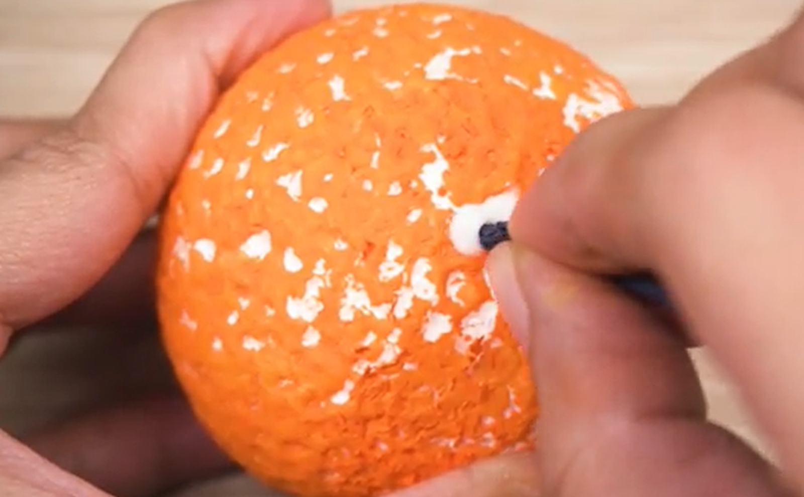 Zdjęcie przedstawia przeciąganie sznurka przez styropianową kulę.