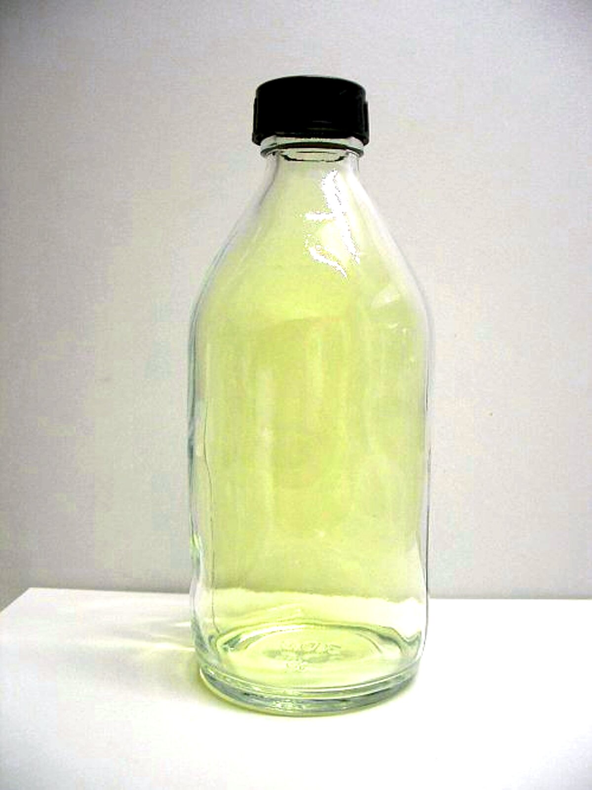 Zdjęcie przedstawia szczelnie zakorkowaną szklaną butlę wypełnioną gazem o żółtawej barwie.