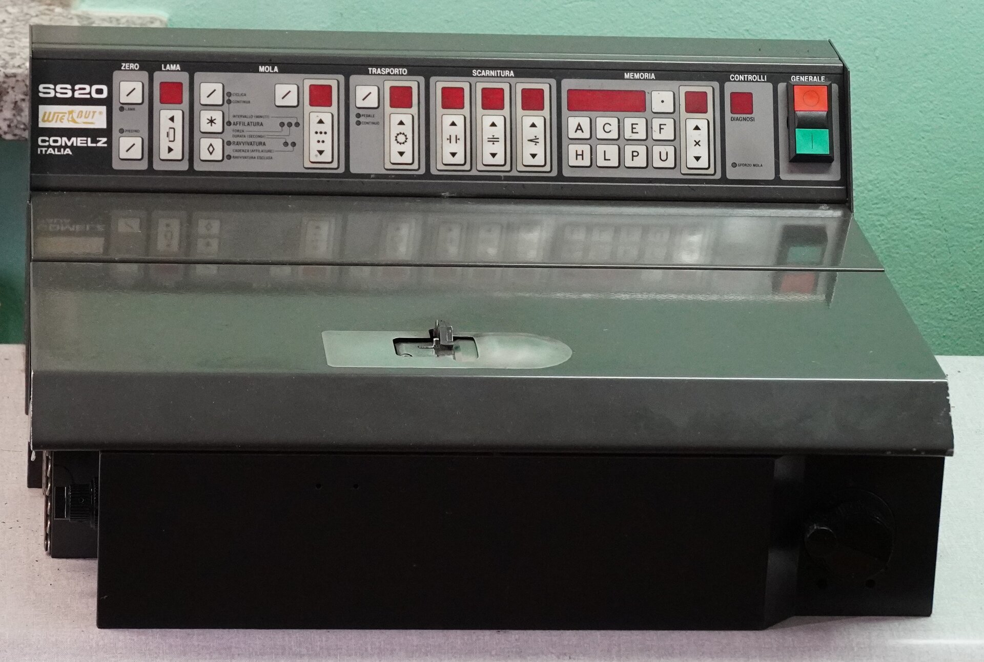 Zdjęcie przedstawia duże czarne wolnostojące urządzenie. U jego szczytu jest umieszczony pulpit, na którym znajdują się różne przyciski. Nagranie tożsame z treścią.