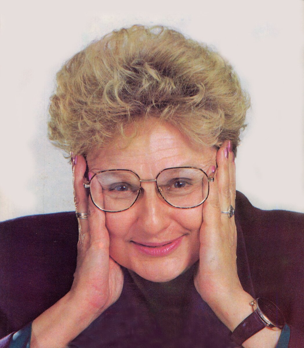 Zdjęcie portretowe przedstawia Ewę Łętowską. Jest to kobieta w średnim wieku. Ma krótkie blond włosy, okulary, pomalowane usta w lekkim uśmiechu i delikatne zmarszczki na czole. Dłońmi podbiera głowę. Ma na sobie ciemny płaszcz. Tło jest białe.