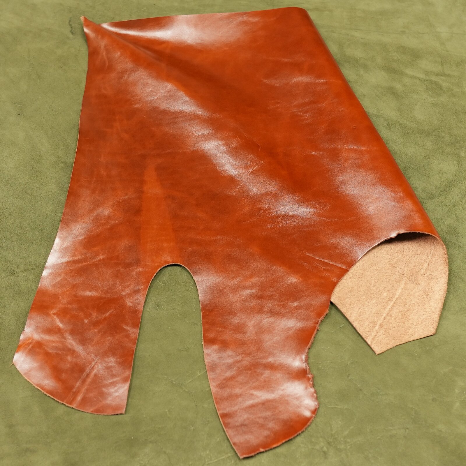 Zdjęcie przedstawia płat skóry bydlęcej. Od strony lica skóra jest brązowa, gładka i błyszcząca. Od strony mizdry jest beżowa i chropowata. 
