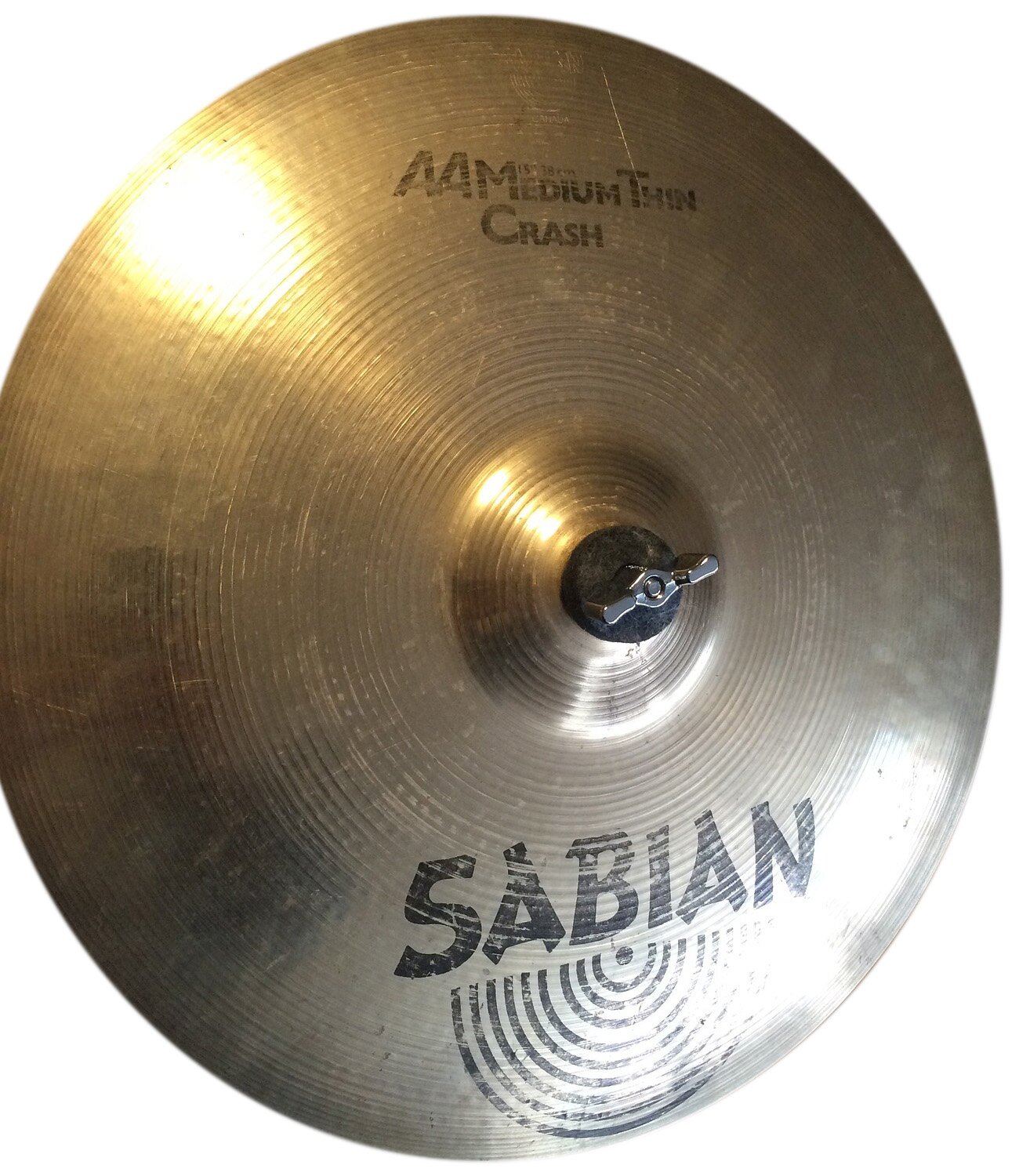 Zdjęcie przedstawia okrągły talerz perkusyjny w kolorze starego złota, z lekko wypukłą, okrągłą częścią pośrodku, w której umieszczone jest czarne pokrętło motylkowe. W górnej i dolnej części talerza czarne napisy i logo.