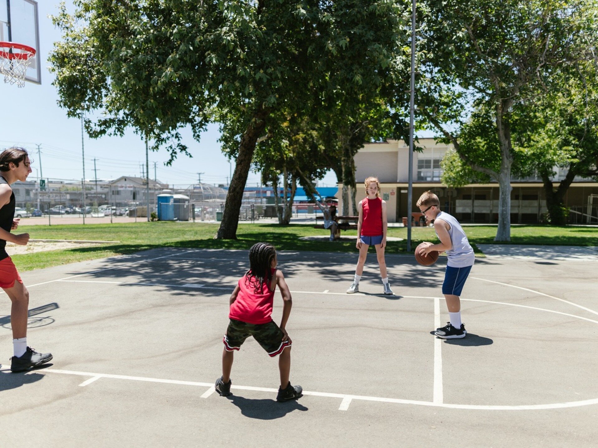 Zdjęcie przedstawiające grupkę dzieci grających w koszykówkę.