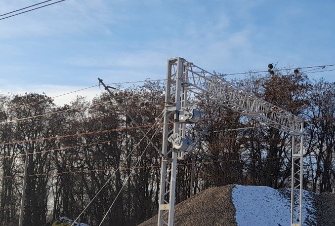 Ilustracja przedstawia linie sieciowe podwieszone do wysięgnika.