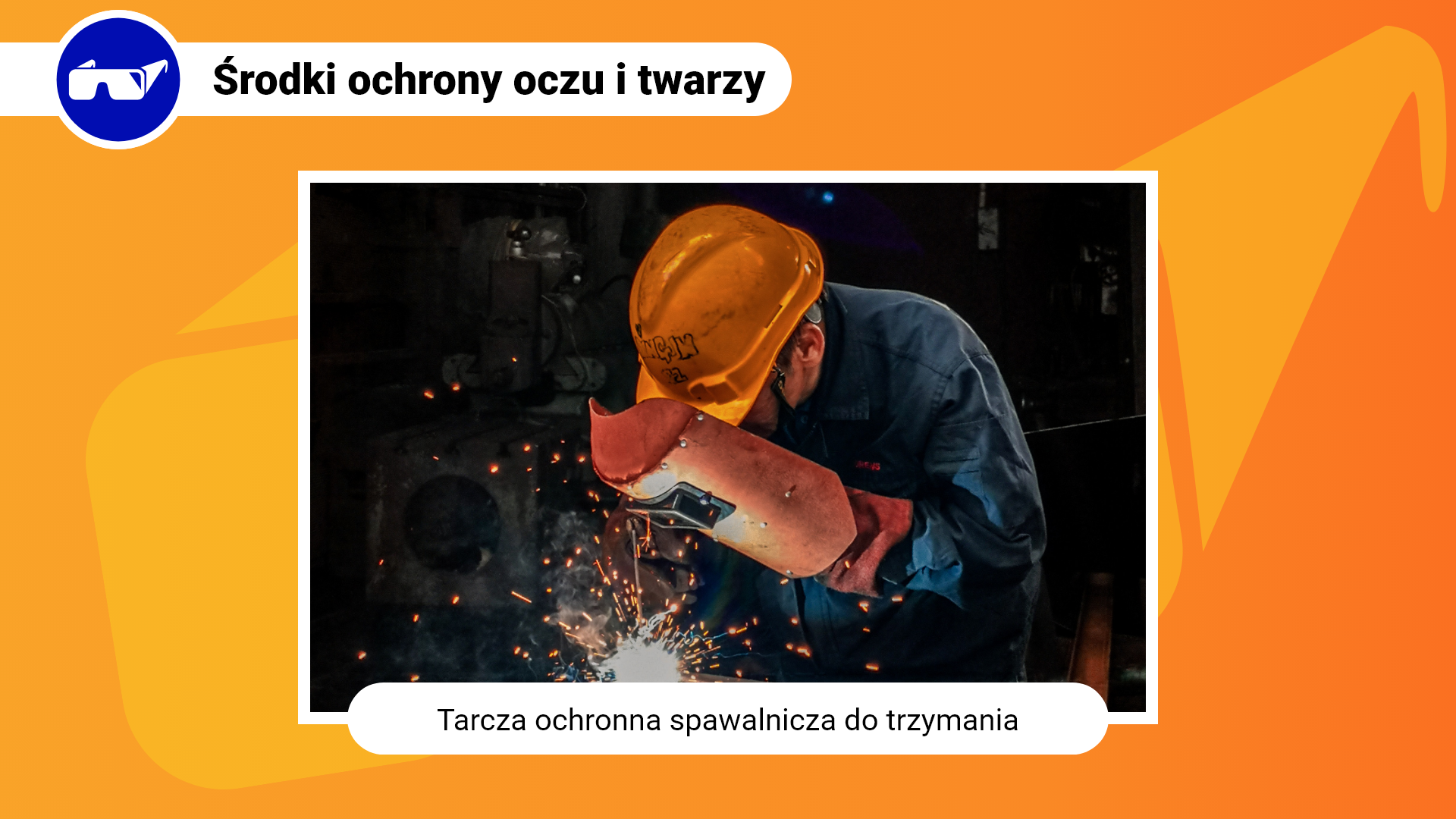 Zdjęcie w ramce z podpisem: tarcza ochronna spawalnicza do trzymania. Przedstawia zbliżenie na mężczyznę, który coś spawa. Znad miejsca spawania unoszą się iskry. Mężczyzna w dłoni trzyma tarczę, którą zakrywa twarz. Tarcza posiada przyciemniony okular umożliwiający patrzenie na spawane elementy. Dodatkowo mężczyzna ma na głowie pomarańczowy kask, ubrany jest w granatowy strój ochronny, a na rękach ma rękawice.