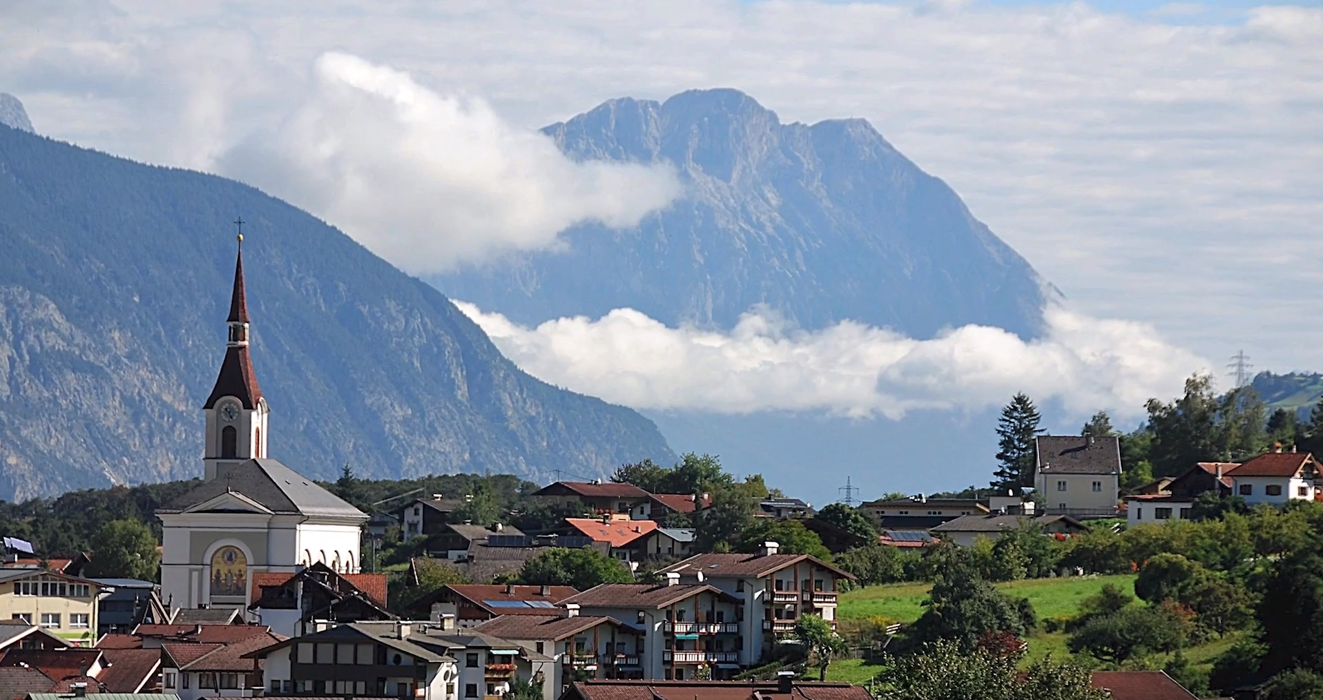 Scena przedstawia miasteczka usytuowane u podnóża gór w różnych porach roku – pięknie nasłonecznione w lecie i ośnieżone w zimie. Na kolejnym zdjęciu pojawia się mężczyzna jeżdżący na nartach, a na następnym widok jeziora na tle gór i lasu.