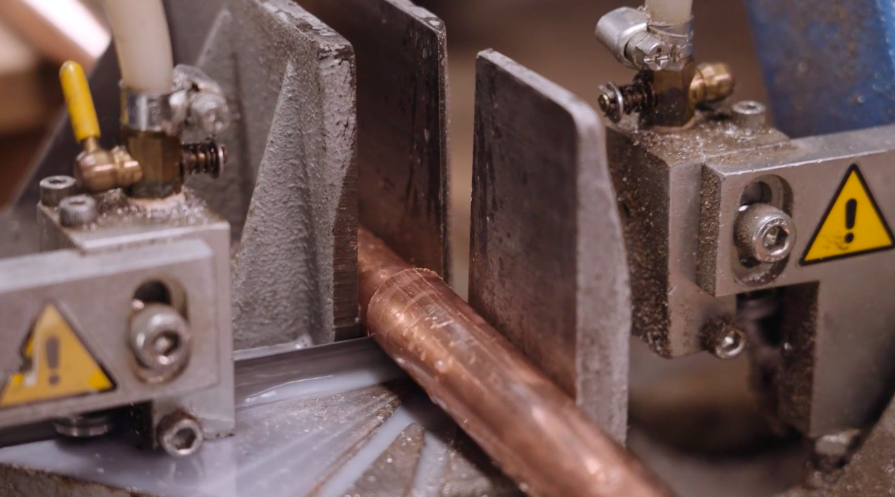 Na zdjęciu widoczna jest niewielka rurka, która leży na przecinarce. Zauważalna jest szczelina, która umożliwia pracę tarczy tnącej. Poniżej ilustracji znajduje się przycisk do odtworzenia nagrania.