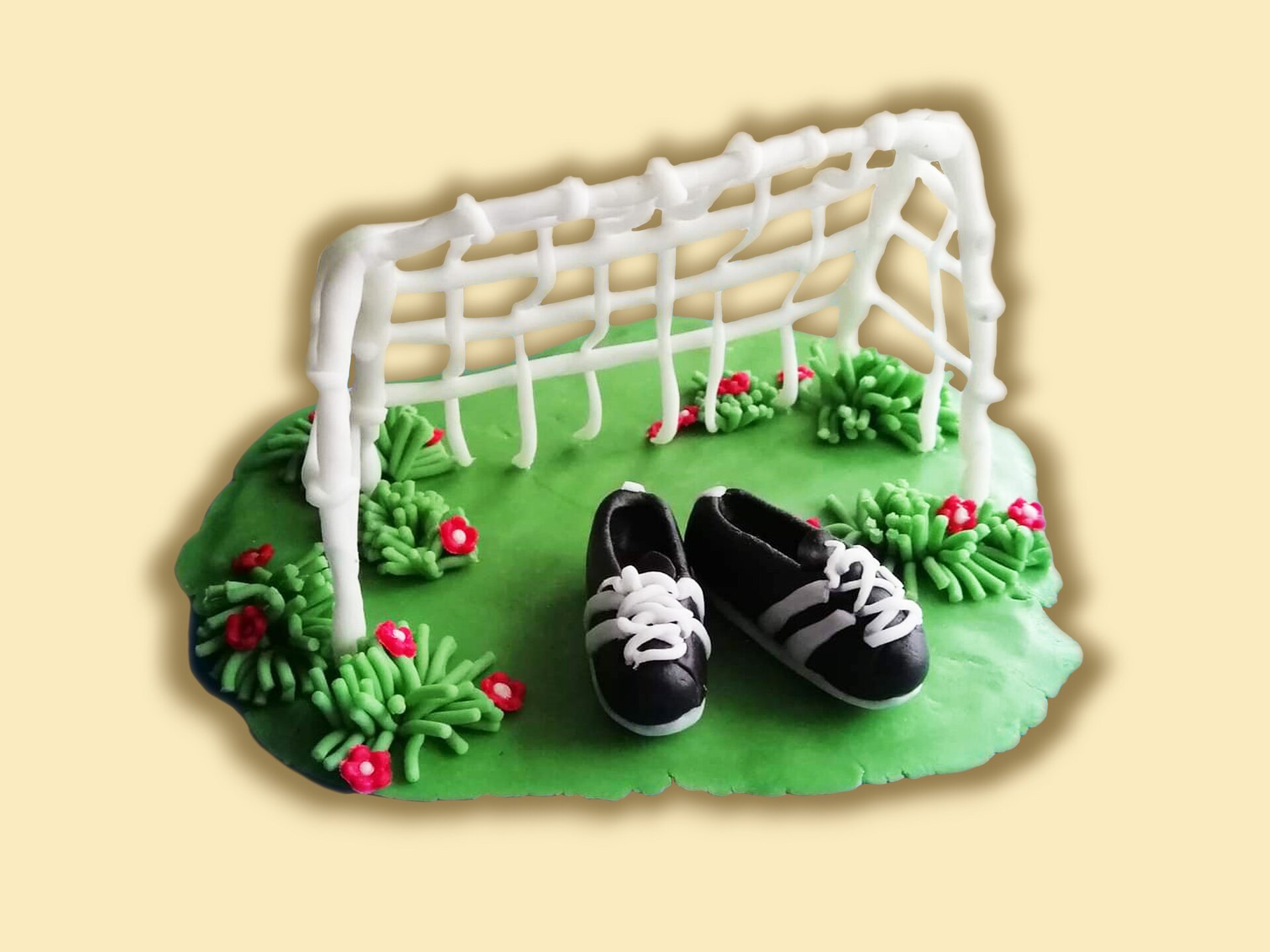 Bramka piłkarska z masy cukrowej, umieszczona na fragmencie murawy.