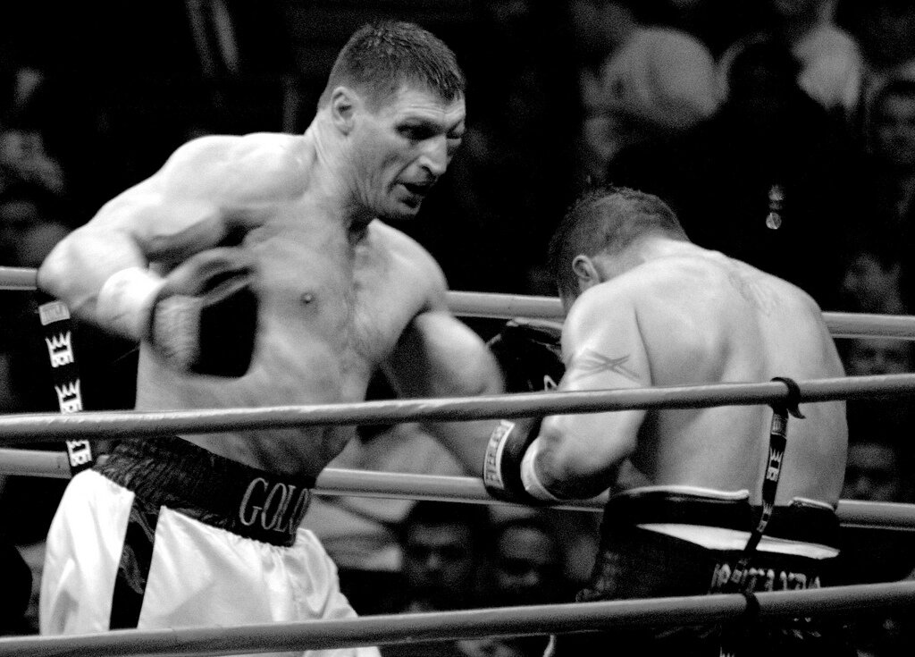 Czarno-białe zdjęcie przedstawia walkę bokserską.