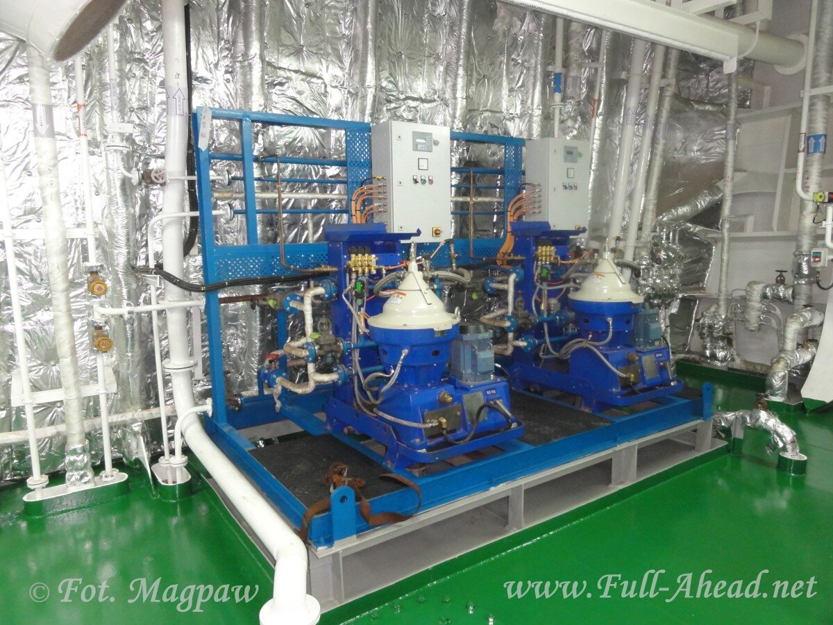 Zdjęcie przedstawia dwie wirówki oleju. Są to stożkowate zbiorniki z licznymi rurkami i kablami.